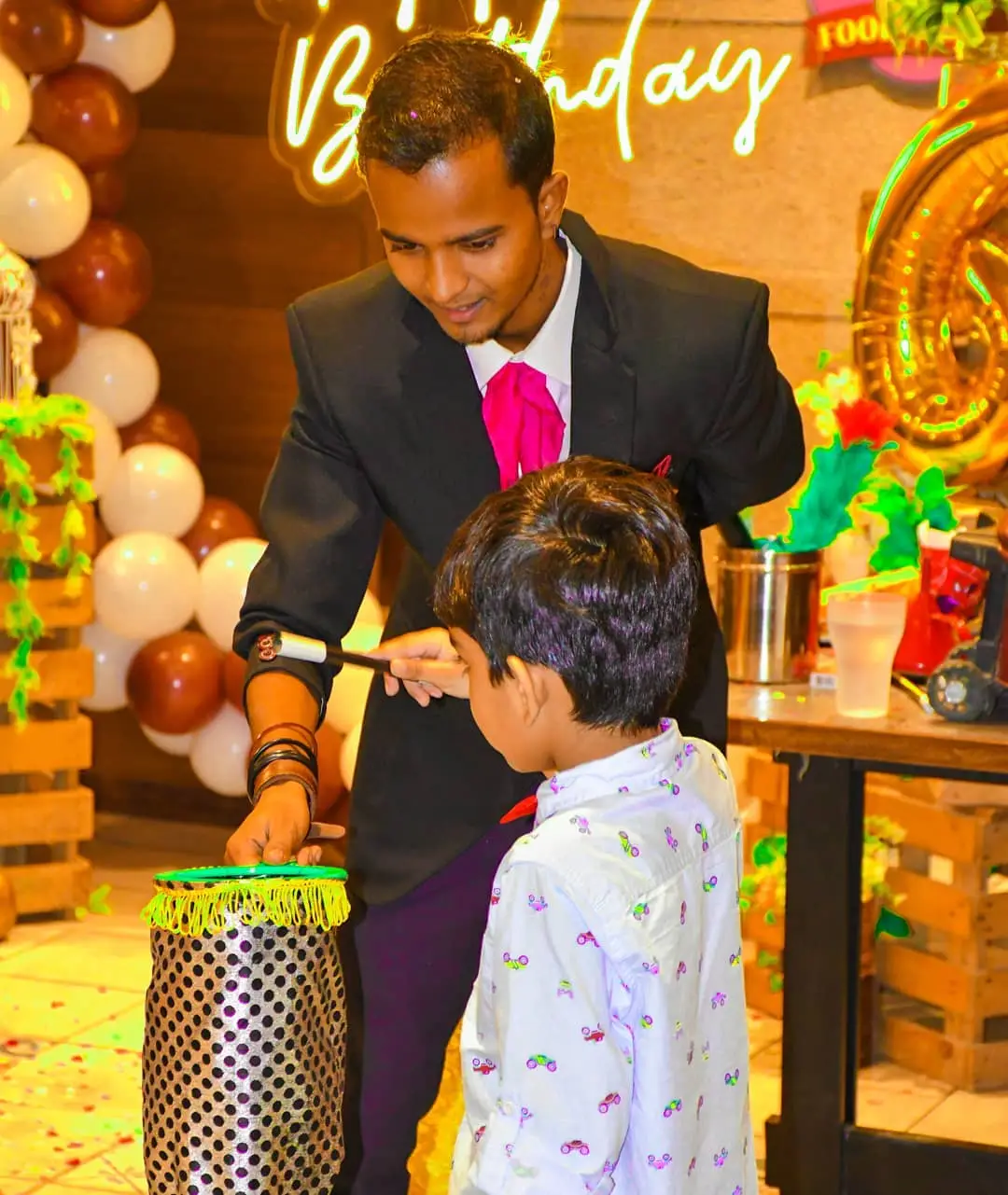 Magician performing a trick with the birthday boy at a kids birthday party in Dubai